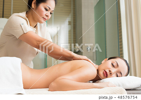 Body Massage on naked back of Mix Race Caucasian Asian woman by pressing fingers on pain or stress muscle point to release relax. Therapist Spa body massage woman hands treatment on customer Body Massage on naked back of Mix Race Caucasian Asian woman by pressing fingers on pain or stress muscle point to release relax. Therapist Spa body massage woman hands treatment on customer 48576754