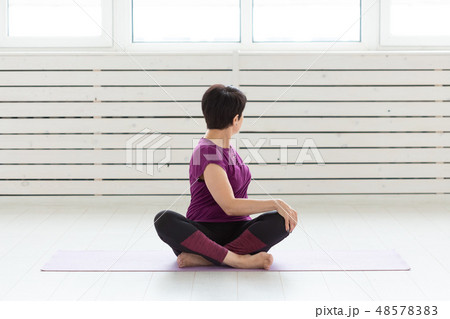 Healthy lifestyle, people and sport concept - Middle aged woman doing yoga 48578383