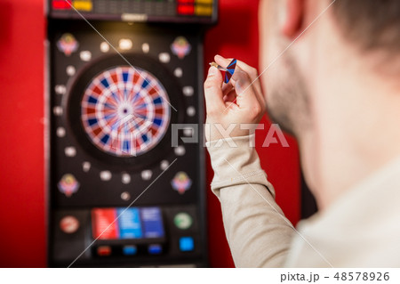 Man aiming against dartboard 48578926