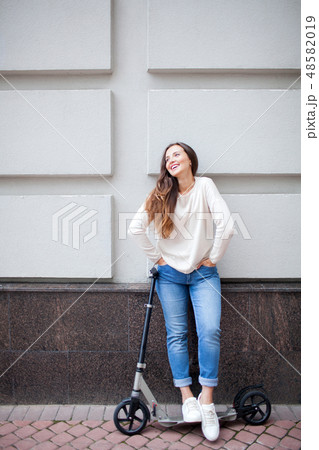 Beautiful young girl stopped while riding the scooter. Beautiful young girl stopped while riding the scooter. 48582019