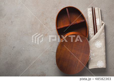 Empty wooden Japanese lunchbox with chopsticks. Empty wooden Japanese lunchbox with chopsticks. 48582363