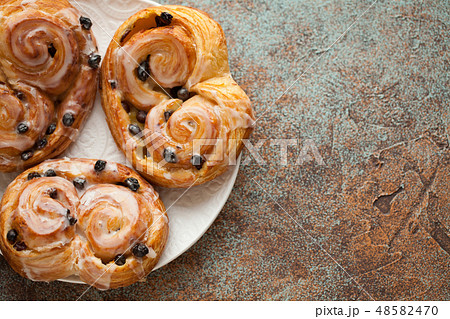 Fresh buns with raisins and icing. 48582470