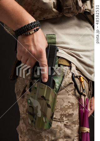 Close-up of a man pulls a gun from his holster. Close-up of a man pulls a gun from his holster. 48582531