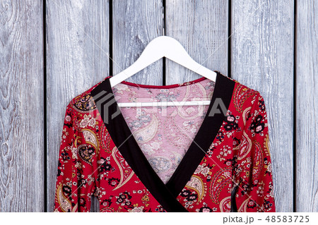 Feminine patterned clothes on hanger. 48583725
