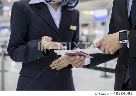空港で航空券を見せて質問をするビジネスマン手元 空港で航空券を見せて質問をするビジネスマン手元 48584092