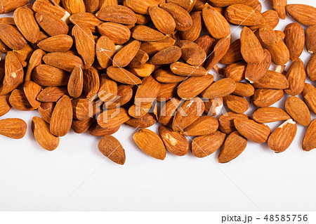 Close up of roasted almonds on white surface, no people Close up of roasted almonds on white surface, no people 48585756