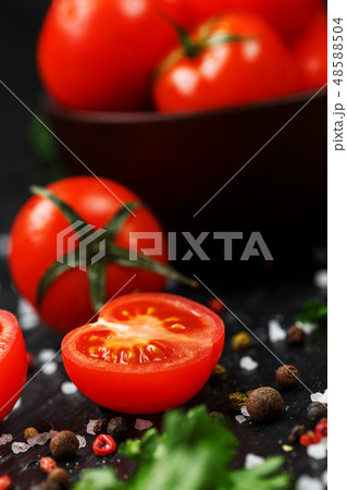 Fresh Tomatoes on a black background with spices Fresh Tomatoes on a black background with spices 48588504