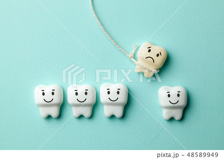 Healthy white teeth are smiling and the removal of the baby tooth with rope is sad on green mint 48589949