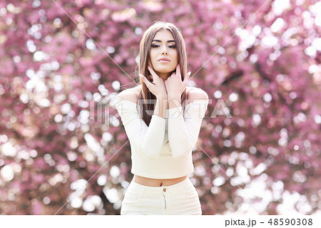 Alone beautiful girl with a romantic hairstyle and a professional make-up enjoys a smell of pink 48590308