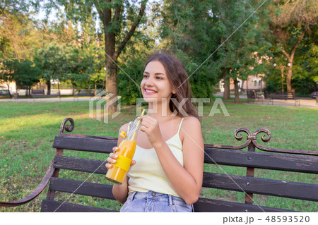 Young pretty girl is having rest on the bench 48593520