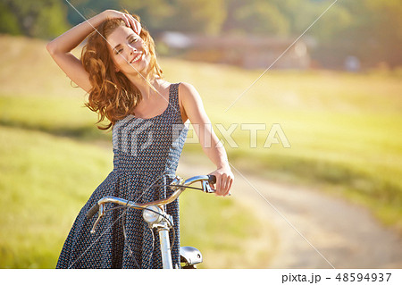 Sexy woman with vintage bike in a country road. Sexy woman with vintage bike in a country road. 48594937