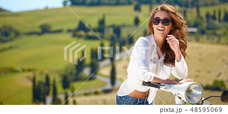 Young beautiful italian woman sitting on a italian scooter in tu Young beautiful italian woman sitting on a italian scooter in tu 48595069