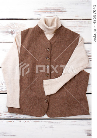 Female brown vest and white sweater. 48597041