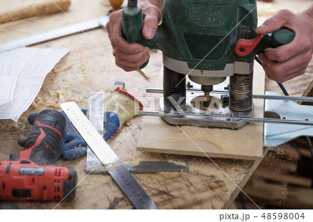 carpenter makes holes with a drill in wooden part carpenter makes holes with a drill in wooden part 48598004