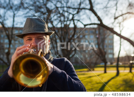 elderly musician plays in the street on a trumpet  48598634