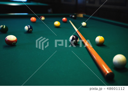 Billiards balls and cue on green billiards table.  48601112
