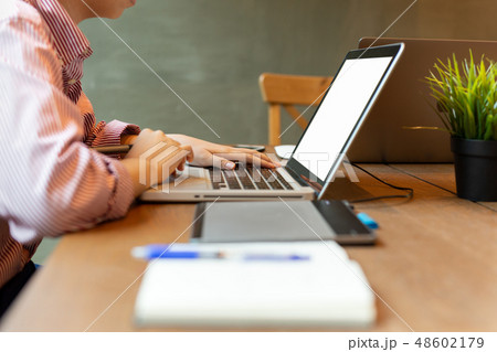 Young woman working on laptop on wooden table. Young woman working on laptop on wooden table. 48602179