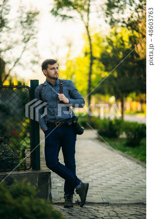 Professional photographer with camera stand outside and wait for the model Professional photographer with camera stand outside and wait for the model 48603763