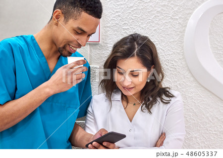 Young african and caucasian dentists on coffee break 48605337