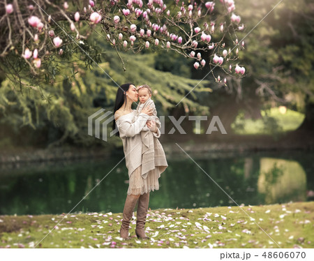 Young and happy mother cares for her young son, and walks along the shore of the lake in the summer Young and happy mother cares for her young son, and walks along the shore of the lake in the summer 48606070