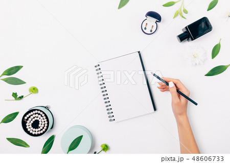 Top view of female hand writing in blank notepad Top view of female hand writing in blank notepad 48606733