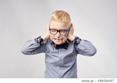Isolated portrait of gaucasian boy covering ears Isolated portrait of gaucasian boy covering ears 48608497