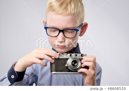 Cheerful smiling child boy holding instant camera 48608520
