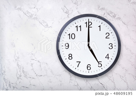 Wall clock show five o'clock on white marble texture. Office clock show 5pm or 5am Wall clock show five o'clock on white marble texture. Office clock show 5pm or 5am 48609195