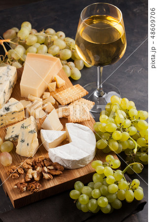 Assorted cheeses with white grapes. 48609706
