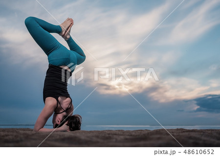 young woman practicing sirsasana. 48610652