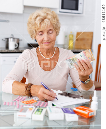 Woman counting her expenditure on pills Woman counting her expenditure on pills 48611169