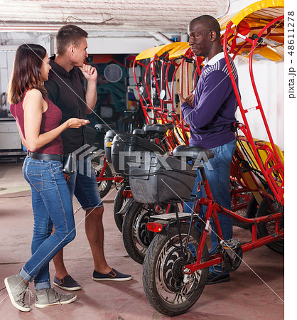 Positive couple planning to hire velotaxi 48611278