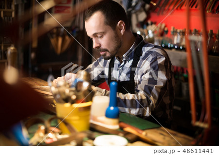 Adult man worker working on belt leather Adult man worker working on belt leather 48611441