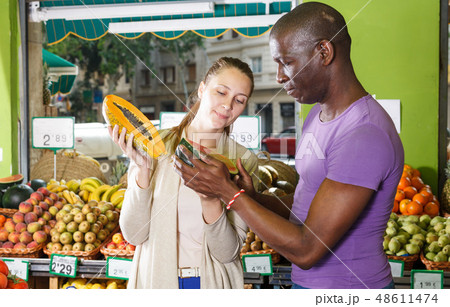 Smiling couple is choosing watermelon and melon Smiling couple is choosing watermelon and melon 48611474