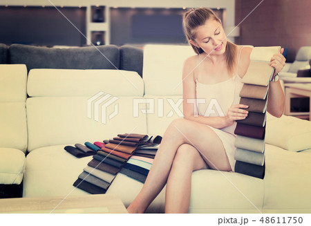 Adult female choosing quality textile on sofa in the furniture s 48611750