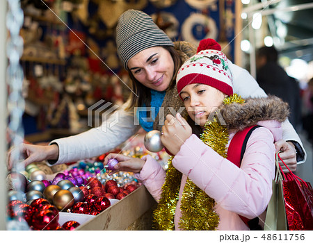 joyous mother with little daughter buying decorations for Xmas 48611756