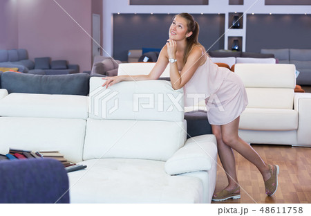 Portrait of glad woman consumer choosing sofa 48611758