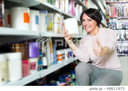 Elegant female customer buying conditioner for hair Elegant female customer buying conditioner for hair 48611975