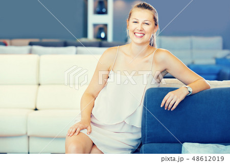 Adult female touching sofa in the furniture store before the buying 48612019