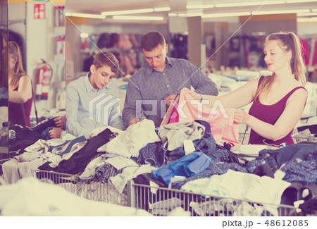 Buyers considering a choice of clothes Buyers considering a choice of clothes 48612085