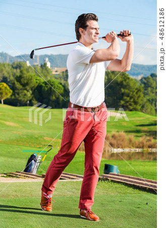 Male golf player made successful hit at golf course 48612186