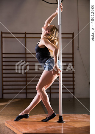 Attractive sports girl dancer engaged on pylon at gym Attractive sports girl dancer engaged on pylon at gym 48612636