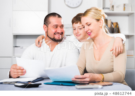 Smiling family with papers Smiling family with papers 48612744