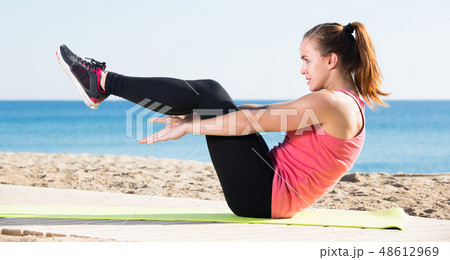 Cheerful young sporty woman exercising 48612969