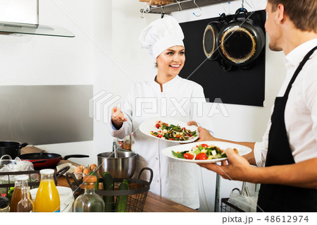 Chef giving salad to waitress 48612974