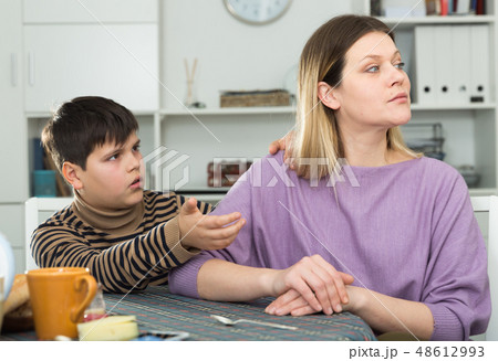 Small boy wants to make peace with his mother after arguing at table 48612993