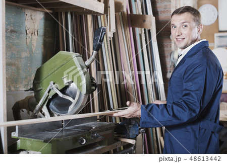 Man operating circular saw in wood workshop 48613442