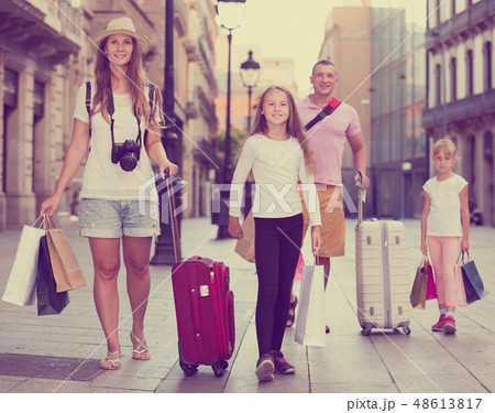 Active family of tourists walking with suitcases Active family of tourists walking with suitcases 48613817