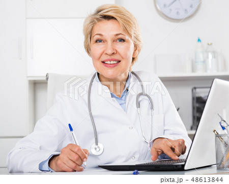 Doctor in gown waiting for patient Doctor in gown waiting for patient 48613844