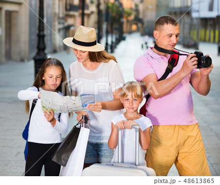 Tourist family using map and taking photo of city while strolling 48613865